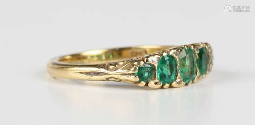 An 18ct gold, emerald and diamond ring, mounted with a row o...