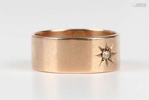 A 9ct gold wide band ring, star set with a cushion cut diamo...