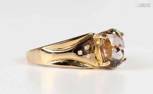 An 18ct gold ring, claw set with the oval cut yellow tanzani...