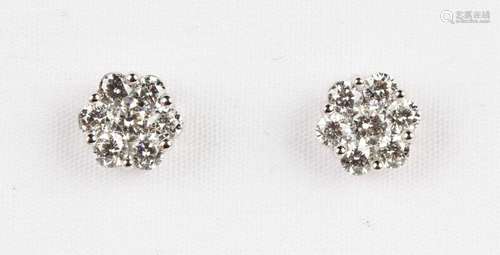 A pair of platinum and diamond seven stone cluster earstuds,...