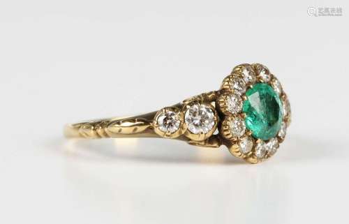 A gold, emerald and diamond cluster ring in a 19th century i...
