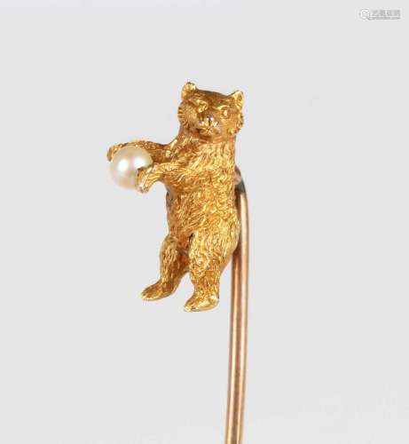 A gold topped stickpin, the finial designed as a standing be...