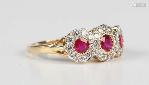 An 18ct gold, ruby and diamond triple cluster ring, mounted ...