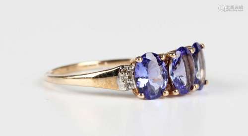 A 9ct gold ring, claw set with three oval cut tanzanites bet...