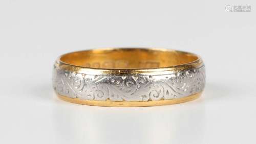 A 22ct gold and platinum wedding ring with engraved decorati...