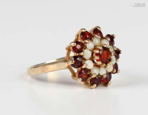 A 9ct gold, garnet and opal cluster ring, claw set with the ...