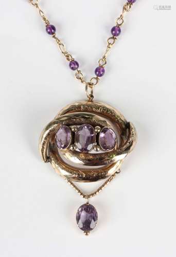 A Victorian gold and amethyst pendant in an oval openwork de...