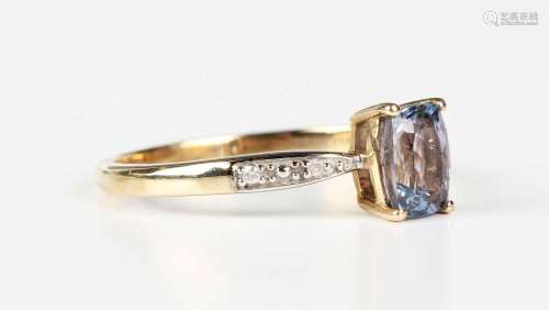 A 9ct gold ring, claw set with a cushion cut tanzanite betwe...