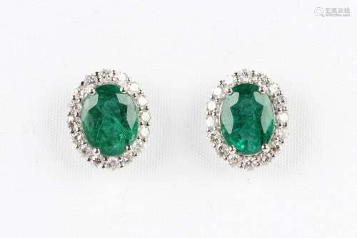 A pair of white gold, treated emerald and diamond oval clust...