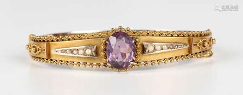 A 9ct gold, amethyst and seed pearl oval hinged bangle, claw...