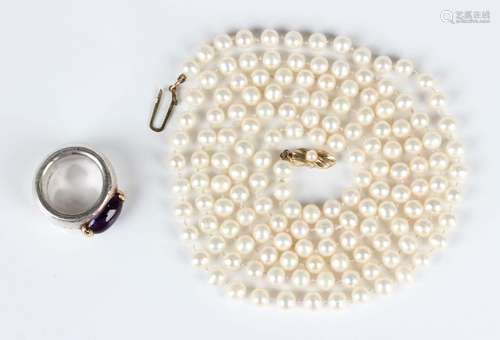 A single row necklace of uniform cultured pearls on a gold a...