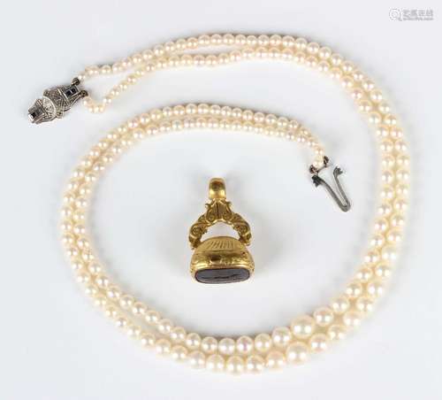 A two row necklace of graduated cultured pearls on a white g...