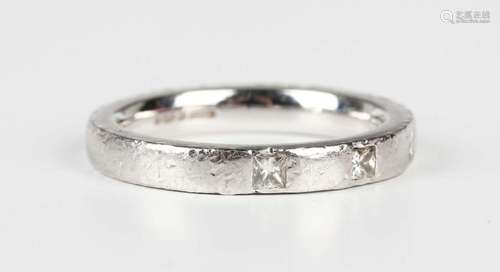 A platinum band ring, mounted with three princess cut diamon...