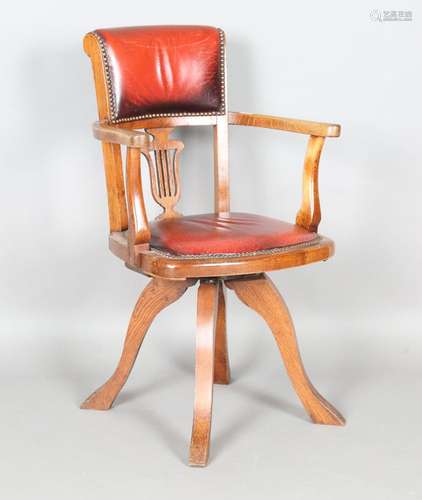 An early 20th century oak framed revolving desk armchair