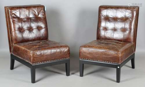 A pair of modern buttoned brown leather easy chairs with bra...