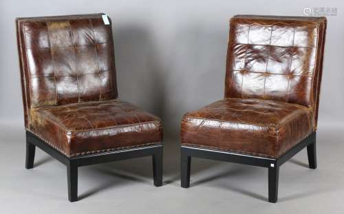 A pair of modern buttoned brown leather easy chairs with bra...