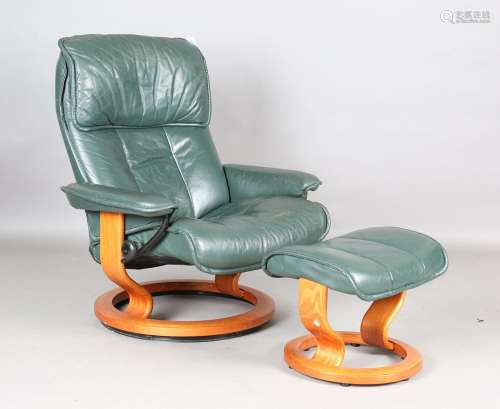 An Ekornes 'Stressless' green leather reclining armchair and...