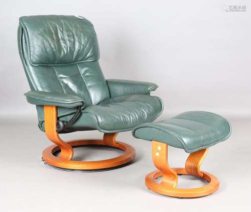 An Ekornes 'Stressless' green leather reclining armchair and...