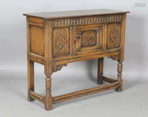 A 20th century Jacobean Revival oak cupboard with carved dec...