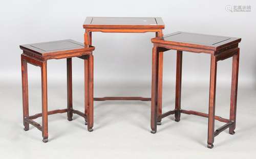 A 20th century Chinese hardwood nest of three tables