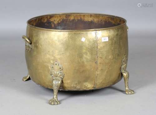 A large early 20th century brass log bin with claw feet
