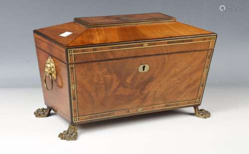 A Regency mahogany and brass inlaid tea caddy of sarcophagus...