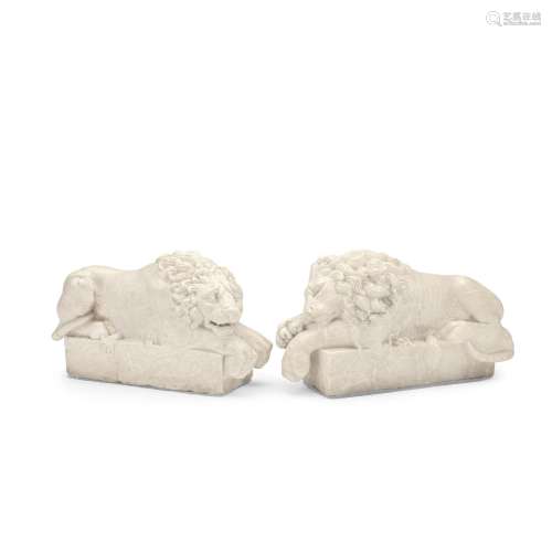 A PAIR OF CARVED ALABASTER RECUMBENT LIONS AFTER THE MODELS ...