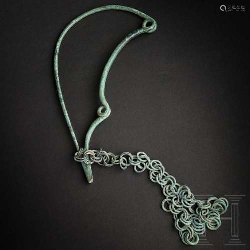 A monumental serpent fibula made of bronze with chain pendan...