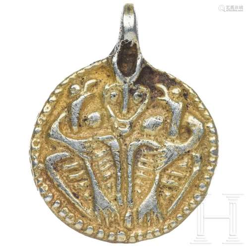 A circular Viking pendant with depiction of Odin with Huginn...