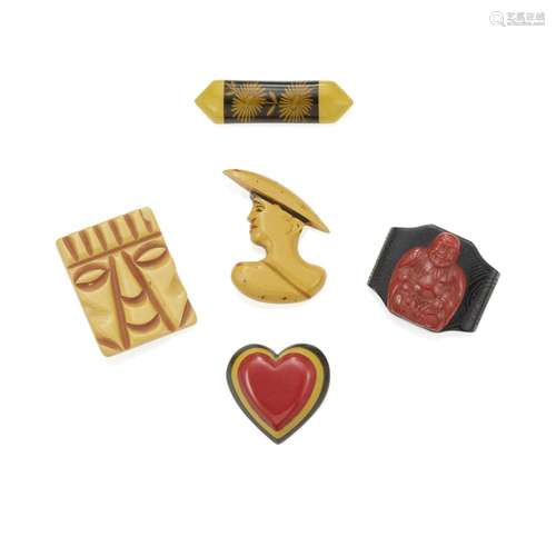 FIVE BAKELITE BROOCHES comprising a butterscotch tiki head, ...