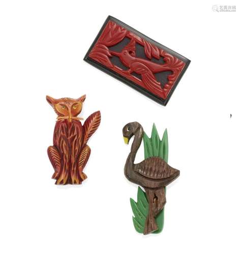 THREE BAKELITE BROOCHES comprising a carved red bird on a bl...