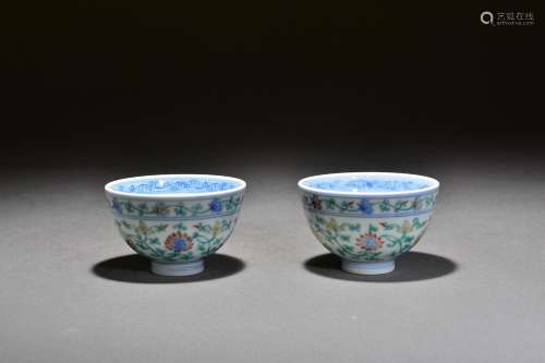 A pair of teacups with tangled branches and lotus patterns