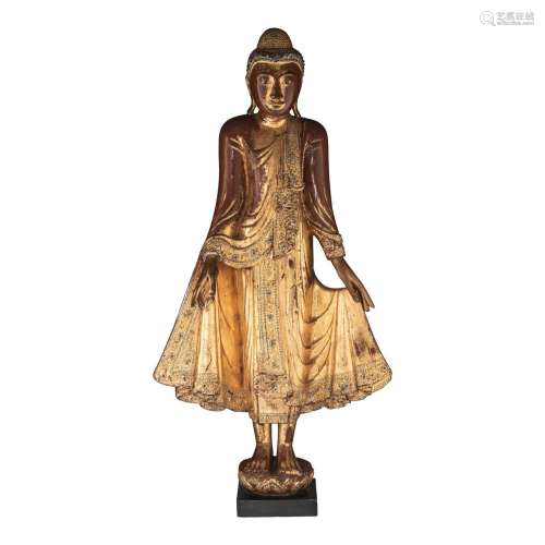A Burmese gilt lacquered wooden figure of a standing Buddha,...