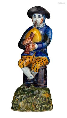 An 18thC Dutch Delft polychrome decorated figurine of a bagp...