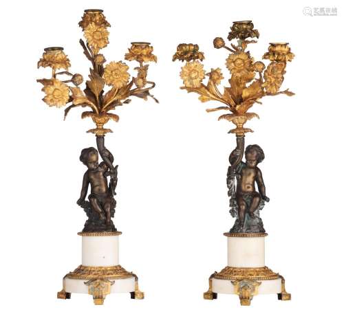 A pair of bronze three-armed candelabras, decorated with put...