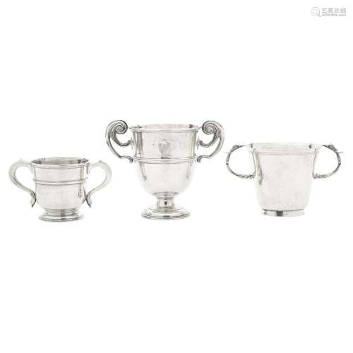THREE ENGLISH SILVER TWO-HANDLED TROPHY CUPS by various make...