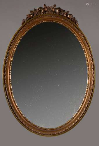 Miroir ovale, le cadre en bois sculpté et doré à décor