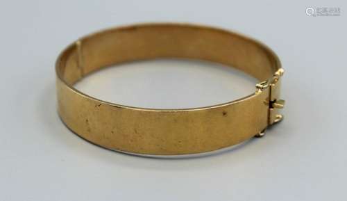 A substantial yellow metal hinged bangle, with a box clasp a...