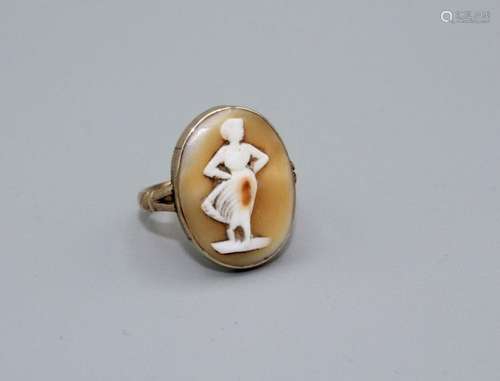 A shell cameo ring depicting the figure of a standing woman,...