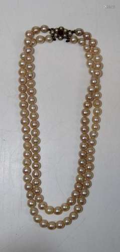 A double stranded pearl choker with a yellow metal clasp, st...