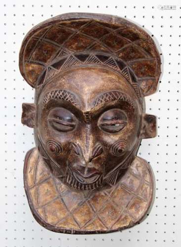 A 20th century carved wood African tribal mask with pursed m...