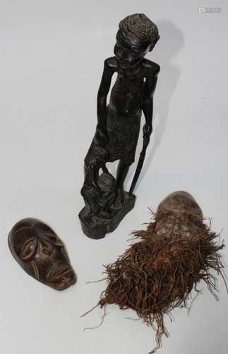 A 20th century carved ebony group of a father holding a gour...