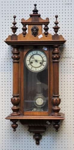 A late 19th century walnut cased Vienna wall clock, the twin...