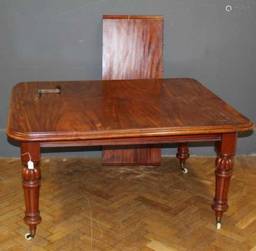 A late Victorian draw leaf dining table raised on ring turne...