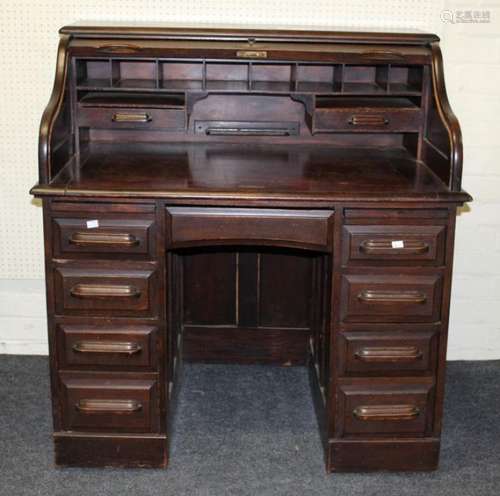 An early 20th century oak roll top desk, the fall enclosing ...