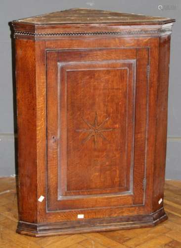 An early 19th century oak wall mounting corner cupboard, the...