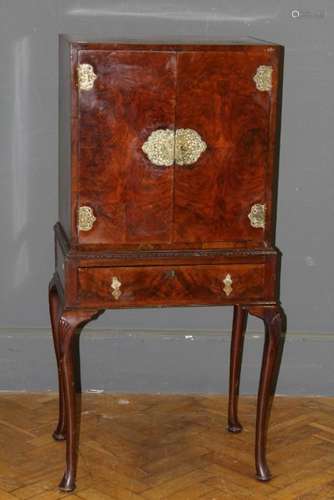 An Edwardian figured walnut cabinet on stand, the pair of do...