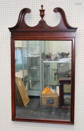 A 20th century mahogany wall mirror, the urn and broken swan...