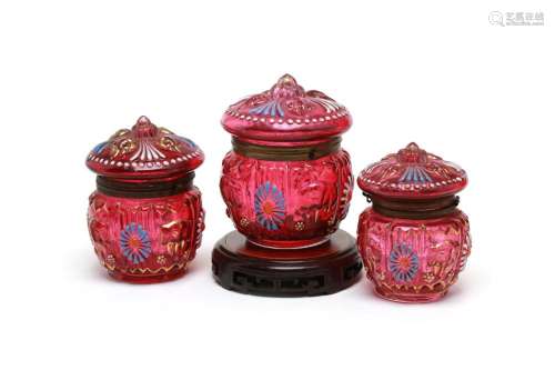 A group of pink glass cosmetic set containers decorated with...