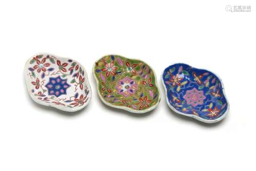 Three polychrome porcelain saucer, each painted with flowers...